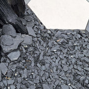 An image showing Spanish Lakeland Blue Slate Aggregate Chippings when laid has part of a garden.