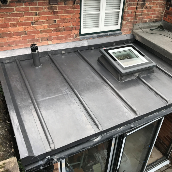 An image of a conservatory roof covered with Code 5 Lead. It is formed around a skylight and also a vent.