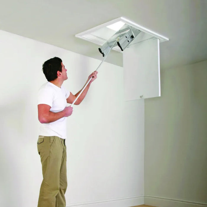 An image of a Manthorpe Sectioned Loft Ladder with someone climbing using a pole to bring it down.