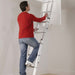 An image of a Manthorpe GLL257 3 Section Loft Ladder with someone climbing up it to show the size.