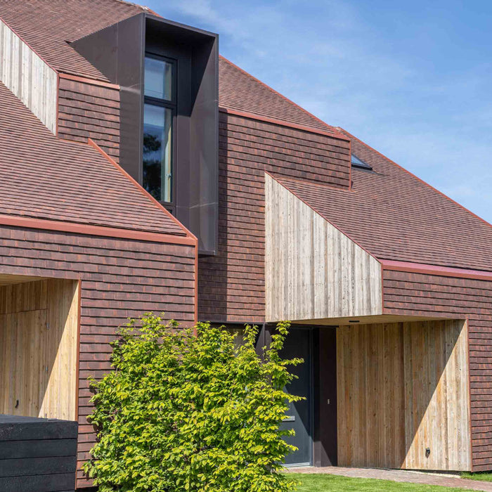 An image of a roof and walls fitted with Marley Concrete Plain Tiles to show what they look like.