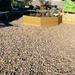 Image of aggregates in the colour Pink Champagne in 20mm. They are tan and pink shades. The image shows what it looks like laid out on a large patio