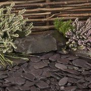 An aggregate image of Plum Slate paddle stones laid as a border to show what they look like when wet