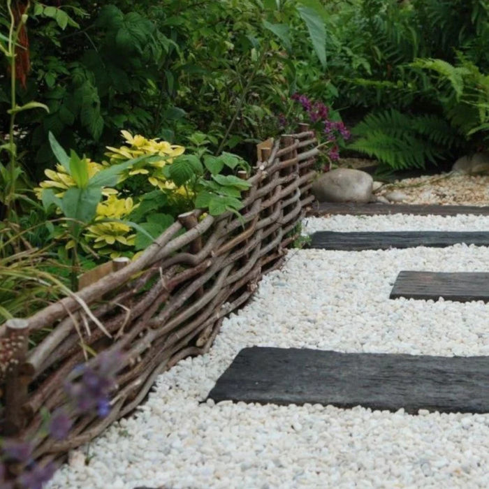 An image of Polar White Garden stones and what they look like when used in a garden around dark slabs.