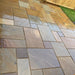 Am image of Rippon Buff Indian Sandstone Paving laid out to show how it looks when wet.