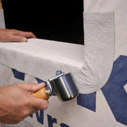 A image showing a Rooftec Steel Seam Hand Roller being used to smooth out seaming tape.