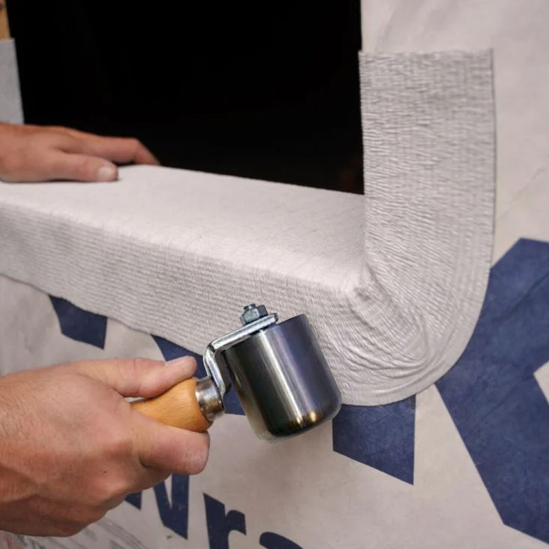 A image showing a Rooftec Steel Seam Hand Roller being used to smooth out seaming tape.