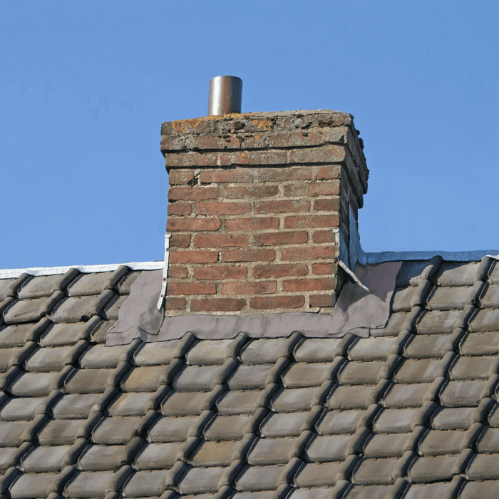 An image of the base of a chimney stack with Rose Roofing Self Adhesive Flashing Tape applied to seal the join between the tiles and brick.