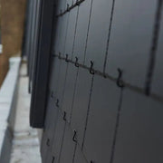 An image of a steep roof fitted with SVK Montana Fibre Cement Slates held in place with slate hooks.