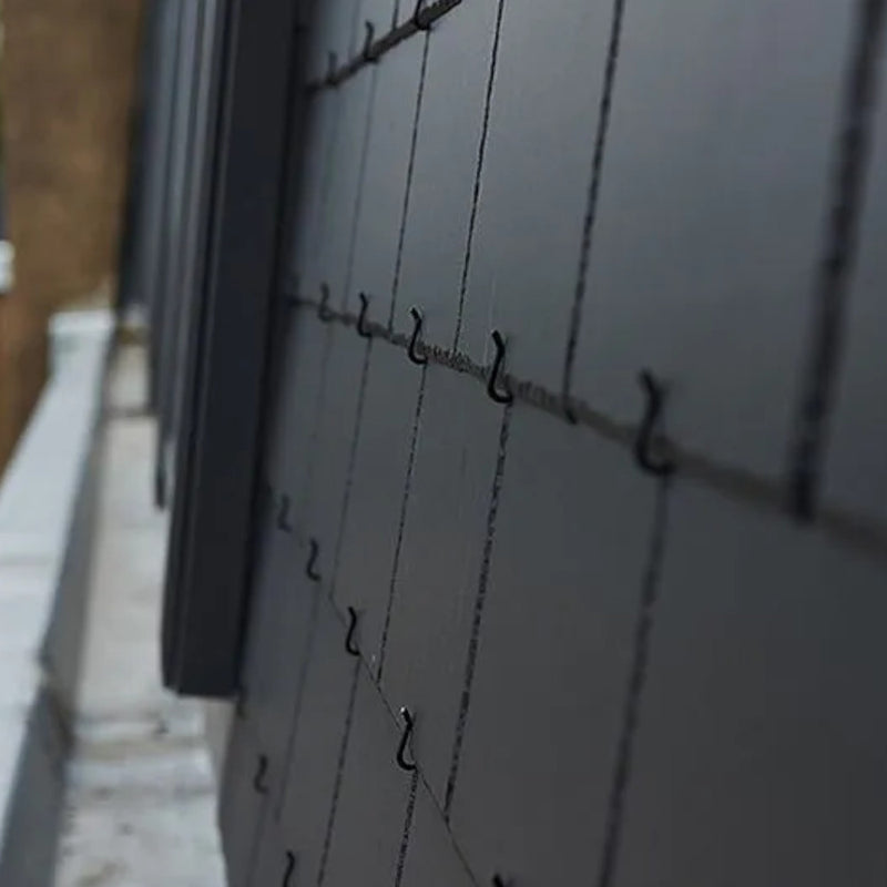An image of a steep roof fitted with SVK Montana Fibre Cement Slates held in place with slate hooks.