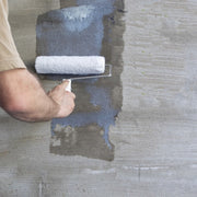 An image of Sika Contrators pva admixture being applied to a plastered surface with a roller.