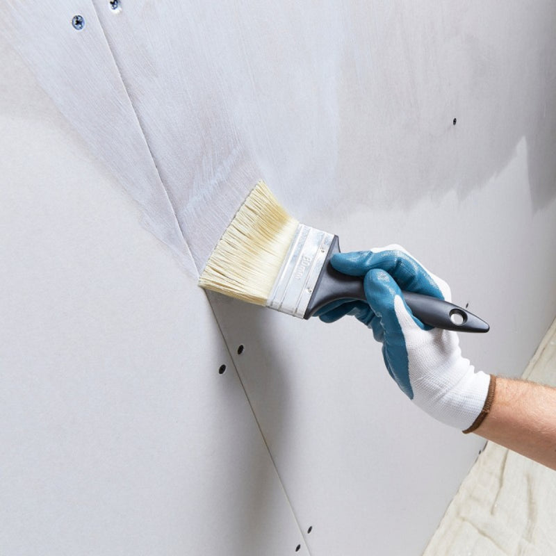 An image of Sika Contractors pva admixture being applied to plasterboard with a brush