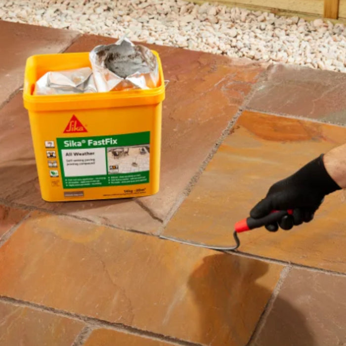 An image of Sika Fast Fix being pressed into the gaps in some paving slabs.