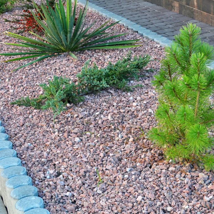 An image of Staffordshire Pink Gravel, 20mm and what it looks like when laid in a garden island