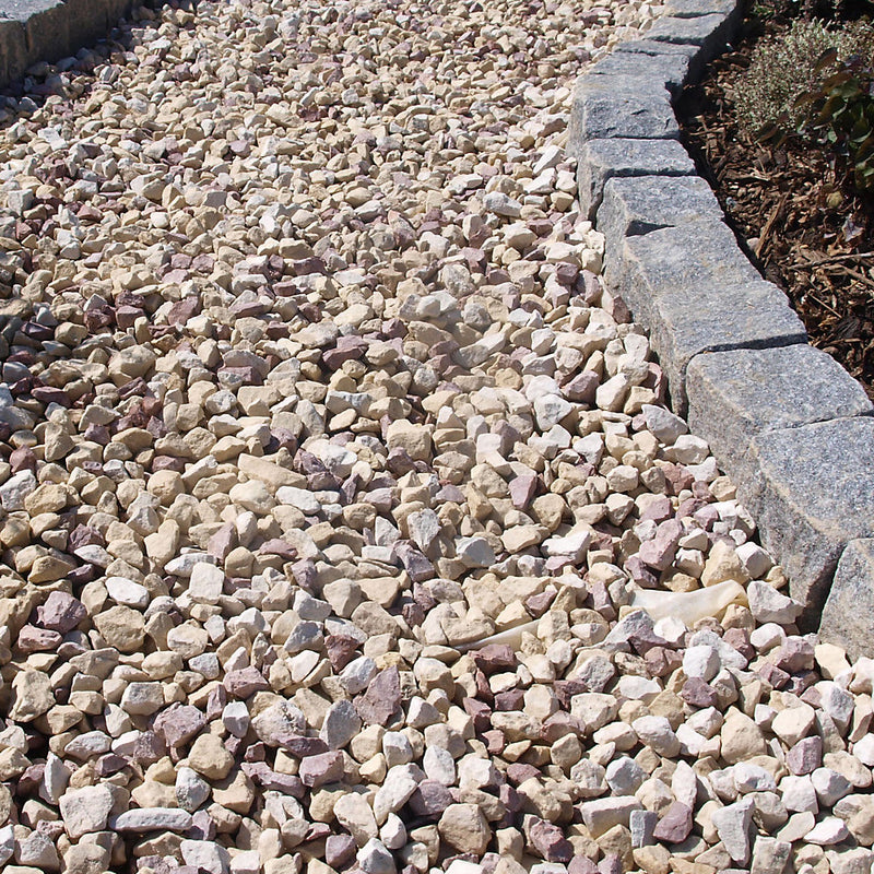 An image of aggregates in the colour Strawberries and Cream. They are in whites, Buffs and red granite and are laid as a pathway with a stone border