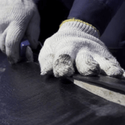 An image of underlay being cut to fit a roof.