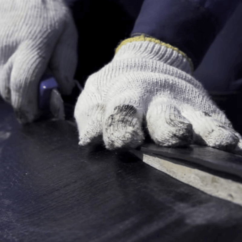 An image of underlay being cut to fit a roof.