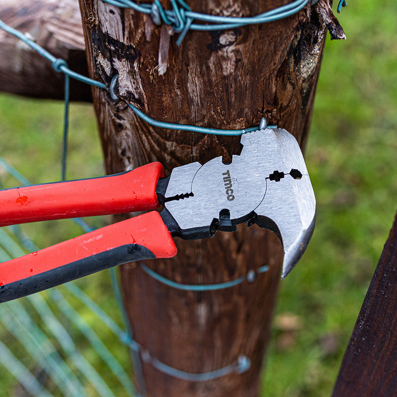 An image of TIMCO Multi-function Fencing Pliers: 13 1/2", 340mm being used to fit a wire fence to a wooden post.
