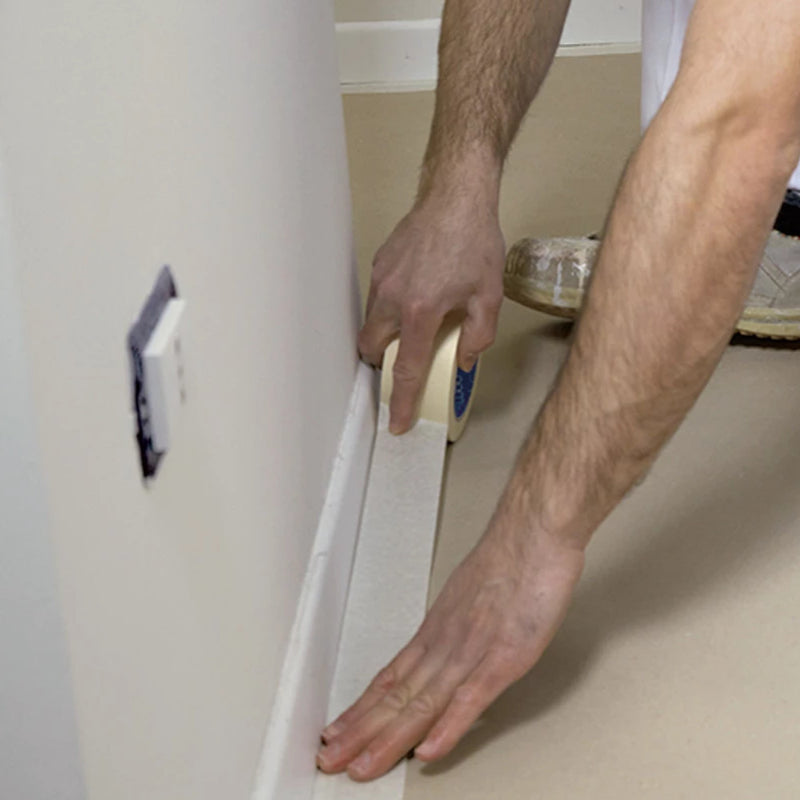 An image showing TMICO 50 x 50 cream masking tape being used to mask up skirting boards.
