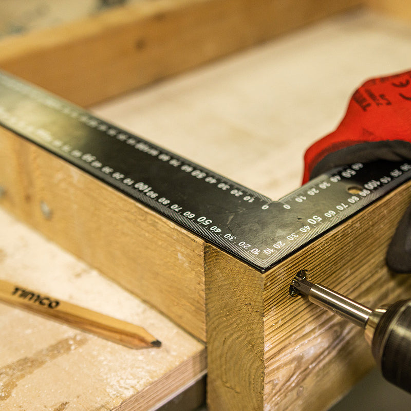 Image of a black Timco Framing and Carpenters Square being used to measure the angle of a timber joint.