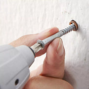 An image showing Timco Premium Plastic Rawl Wall Plugs Brown 42mm tapped into a pre-drilled hole and is being used with a screw.