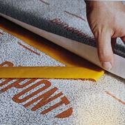 An image that shows Tyvek House Wrap Tape being used to stick overlaps together.