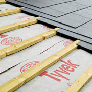 An image of Tyvek Supro Breather membrane being fitted onto a roof under the tiles and beams / lats