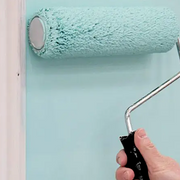 An image showing an Ultra Cage Roller Arm that is 225mm / 9in being used to paint a wall.