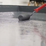 An image of Ultraflex Liquid Roofing being applied onto a roof with a roller.