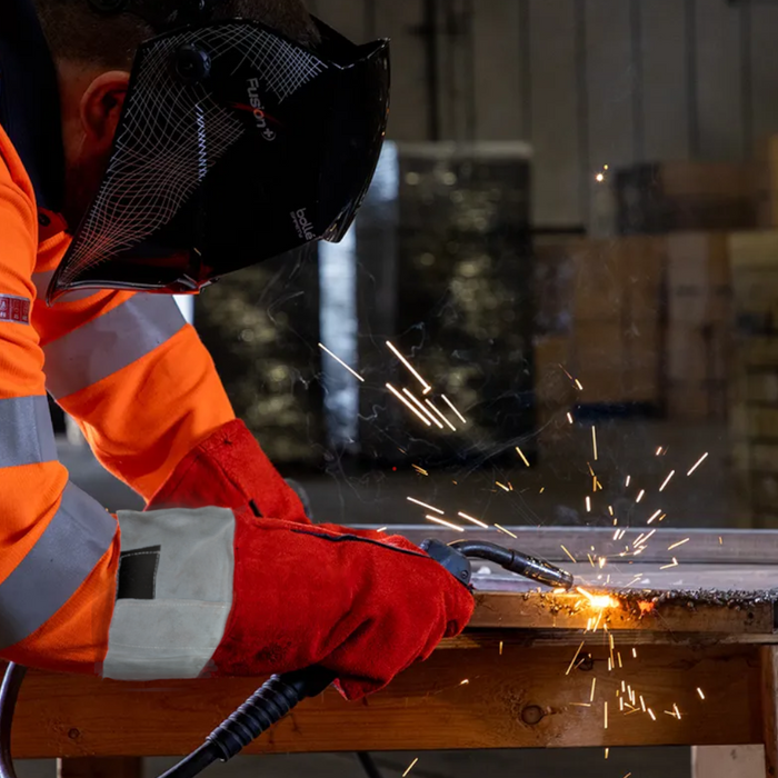 A pair of Red Welders Gauntlets / Gloves that have a grey cuff being used to weld metal.