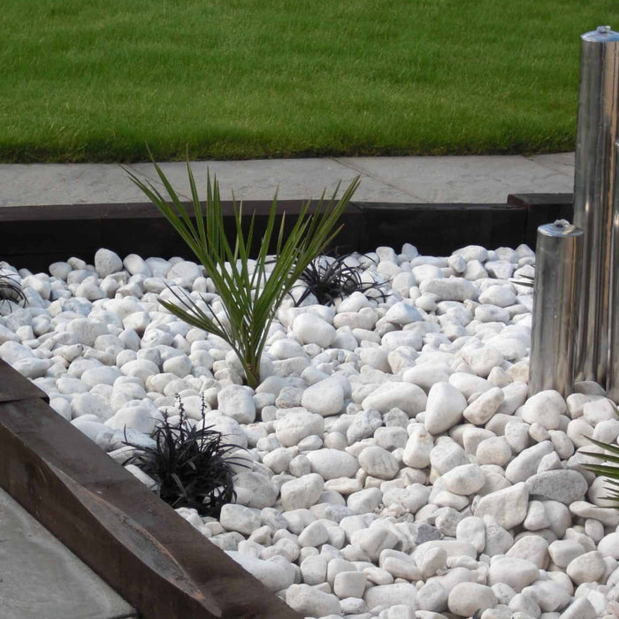 An image of White Cobbles 40-90mm and what they look like when laid as part of a garden island