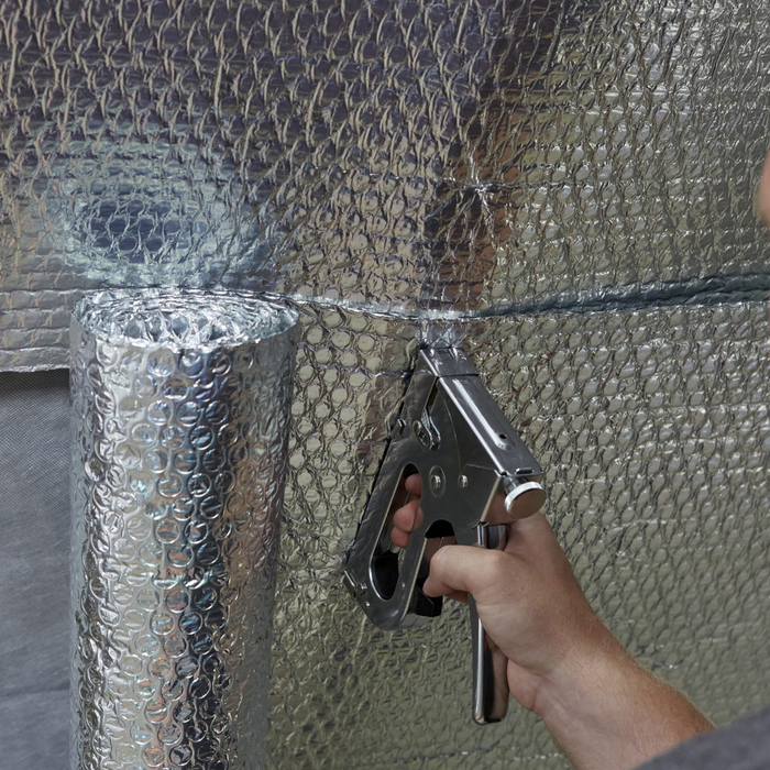 An image of YBS Airtec bubble aluminium foil insulation being staplied to a wall to show how easy it is.