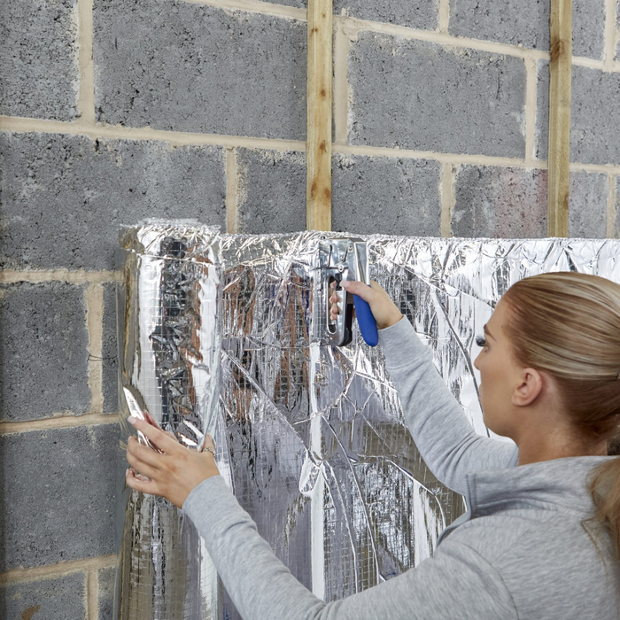 An image of YBS Top-up quilt being stapled to a wall.