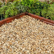 An image showing Yorkshire Cream Aggregates / stones when wet and laid in a garden.