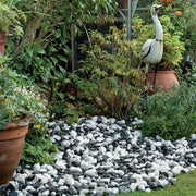 An image showing Zebra Pebble Stone Aggregate Gravel. They are laid as decoration in a garden.