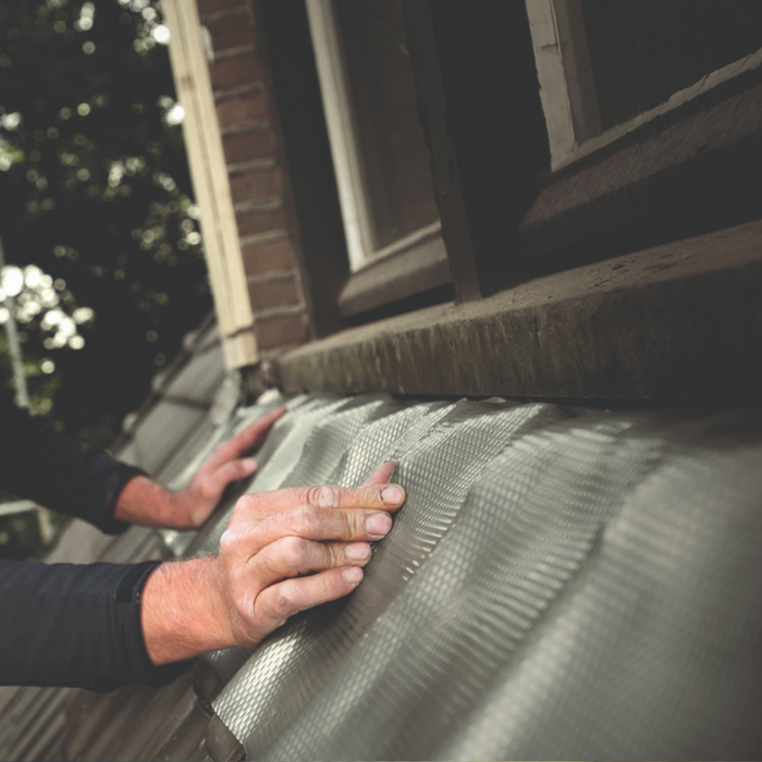 An image of Leadax being fitted as flashing on the side of a house.