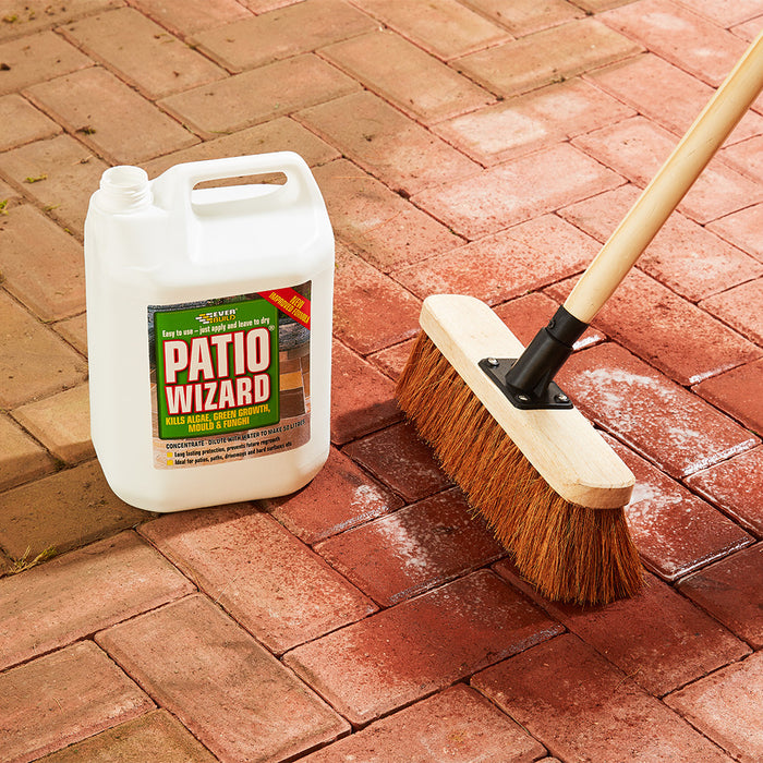 An image of a bottle of Everbuild Patio Wizard in a 5 Litre bottle being brushed onto a patio to remove the Moss and Algae.