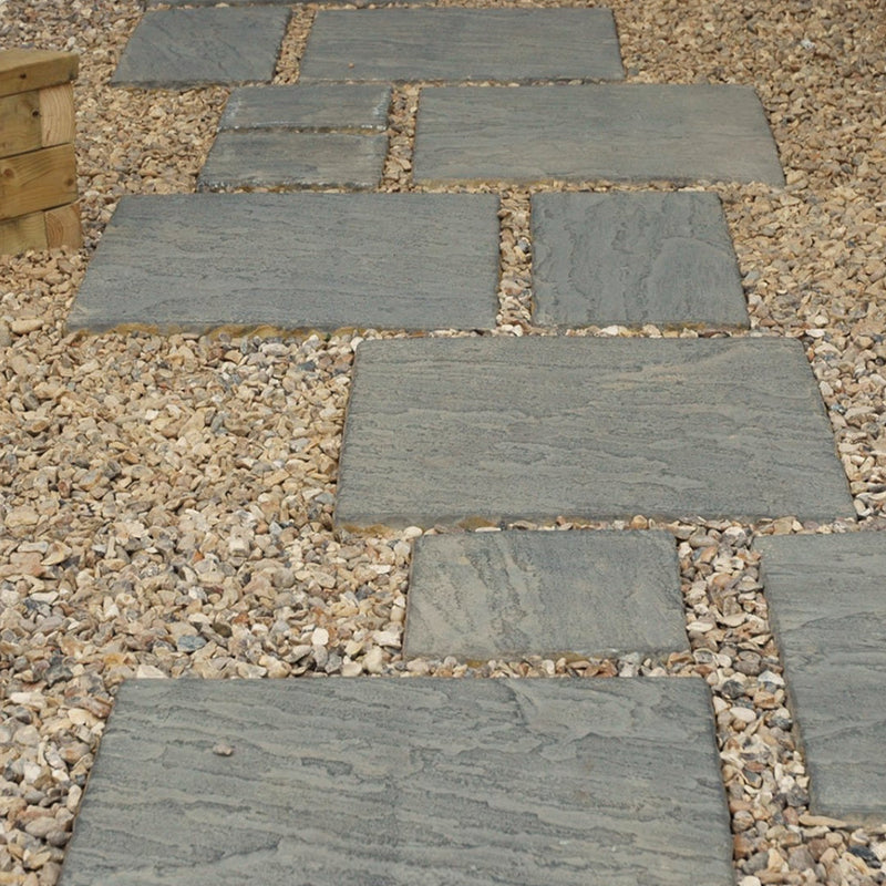 An image of Golden Flint Gravel laid out on a garden path around paving slabs