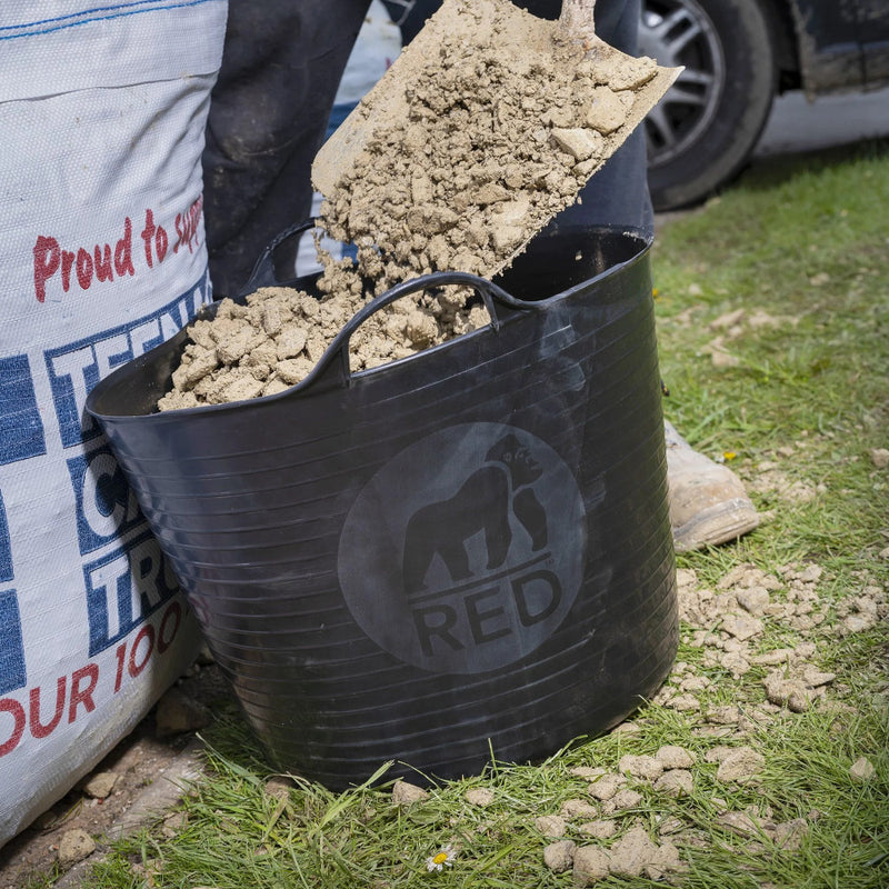 Image of a Red Gorilla Large Tub in Black with a capacity of 38 Litres being loaded up with stones, gravel and debris.