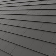 Dark gray Concrete roof tile arranged in overlapping horizontal rows, showing a textured surface 